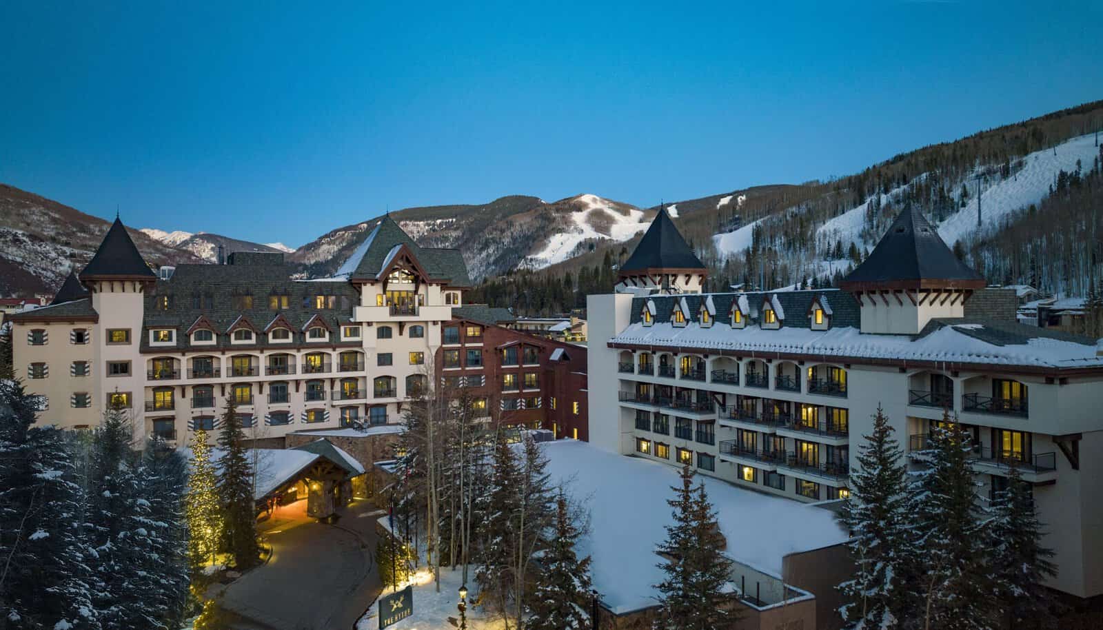 The Hythe hotel buildings and covered entrance below snow-covered Vail Mountain